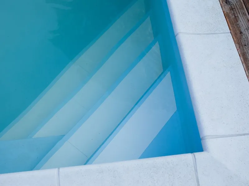 Clean white pool steps and coping after an acid wash and stain removal